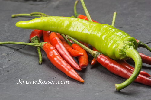 shutterstock_chili red and green chili pepper on nature black stone background 446191165